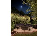 Beautiful patio with lovely outdoor seating, plants and string lights under a full moon at 300 Lakeside Dr, Garner, NC 27529