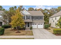 Charming two-story home with a stone facade, a well-maintained lawn, and a two-car garage at 3409 Lily Orchard Way, Apex, NC 27539