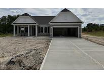 Beautiful new construction home featuring a large garage and a traditional, inviting design with stone accents at 4013 Kingcraig Ln, Zebulon, NC 27597
