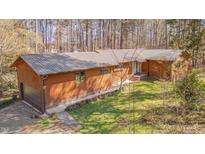 Charming single-story home with a metal roof, wood siding, and an attached garage at 501 Hiddenbrook Dr, Durham, NC 27703