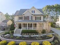 Traditional two-story home featuring a welcoming front porch and beautifully landscaped front yard at 512 Hallburg Ct, Wake Forest, NC 27587