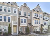 Charming townhomes feature varied exteriors, manicured lawns, and inviting entryways, creating a welcoming street view at 590 Grand Central Sta, Apex, NC 27502