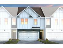 Beautiful townhome exterior showcasing a modern design, attached garage, and welcoming curb appeal at 6004 Enclosure Way, Durham, NC 27703