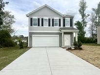 Two-story home features a large garage and a welcoming entrance at 736 Kenyon Spring Dr, Zebulon, NC 27597
