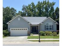 Charming single-story home featuring a gray exterior, well-manicured lawn, and attached two-car garage at 7652 Channery Way, Raleigh, NC 27616