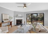 Bright living room featuring a fireplace, stylish decor, and sliding glass doors to the outside at 7706 Falcon Rest Cir, Raleigh, NC 27615