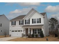 Charming two-story home featuring a covered porch, two-car garage, and black window shutters at 110 Manor Stone Dr, Clayton, NC 27527
