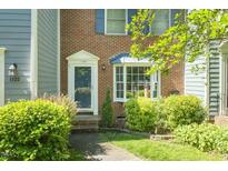 Charming brick townhouse with a well-manicured front garden and bright blue shutters at 1120 Collington Dr, Cary, NC 27511