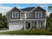 Charming two-story home with a white garage door and lush green landscaping, creating an inviting curb appeal at 1129 Sun Springs Rd, Wake Forest, NC 27587