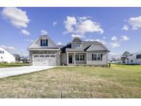 Charming home featuring stone accents, a two-car garage, and a well-manicured lawn at 115 S Harper Faith Way, Benson, NC 27504