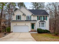 Charming two-story home featuring a green door, green shutters, and attached two-car garage at 12 Montcrest Dr, Durham, NC 27713