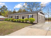 Charming single-story home with a well-maintained lawn and manicured shrubbery at 1230 Melrose Dr, Burlington, NC 27217