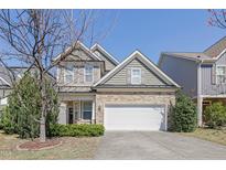 Charming home with stone accents, inviting facade, a two-car garage and well-manicured landscaping at 125 Station Dr, Morrisville, NC 27560