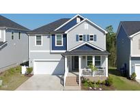 Charming two-story home with a covered front porch, attached garage, and blue and gray color scheme at 1417 Underbrush Dr, Durham, NC 27703