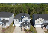 Charming two-story home with a porch, garage, and a well-manicured lawn surrounded by lush trees at 1417 Underbrush Dr, Durham, NC 27703