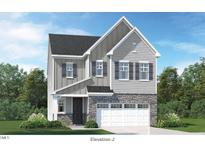Charming two-story home featuring stone accents, gray siding, and a two-car garage for modern curb appeal at 228 Nahunta Dr, Apex, NC 27539