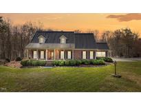 Charming brick home featuring a metal roof, manicured bushes, and a well-maintained front yard at 23901 Nc-902, Bennett, NC 27208