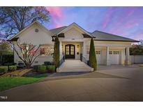 Charming white brick home with manicured landscaping, inviting front entrance, and attached garage at 2704 St Marys St, Raleigh, NC 27609