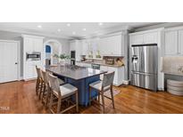 Spacious kitchen features a large island, stainless steel appliances, and hardwood floors at 2704 St Marys St, Raleigh, NC 27609