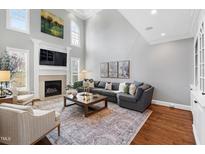 Spacious living room with a fireplace, large sectional sofa, and soaring ceilings at 2704 St Marys St, Raleigh, NC 27609