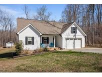 Charming exterior elevation with a two-car garage, a manicured lawn, and a cozy front porch with seating at 302 Weaver Ridge Rd, Rougemont, NC 27572