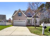 Charming two-story home with a well-manicured lawn, two-car garage, and a cozy front porch at 4005 Freesia Ct, Zebulon, NC 27597
