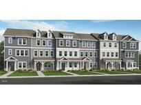 Charming new townhome exteriors with individual entryways and manicured lawns provide a welcoming ambiance at 414 Rowe Way, Knightdale, NC 27545
