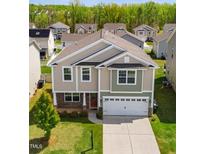 Two-story home featuring a two-car garage, a mix of siding, stone accents, and a well-maintained lawn at 417 Sapphire Rd, Burlington, NC 27215