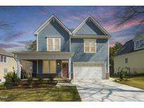 Charming two-story home with light blue siding, a two-car garage and a well-manicured lawn at 604 Whistable Ave, Wake Forest, NC 27587