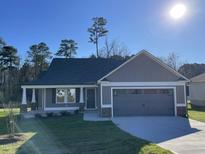 Charming home with a two-car garage, gray siding, covered front porch, and well-manicured lawn at 72 Heatherglenn Cir, Princeton, NC 27569