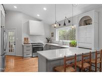 Bright kitchen boasts gray cabinetry, hardwood floors, and large sink with a view of the outdoors at 8504 Old Nc 86, Chapel Hill, NC 27516