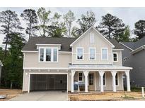 Charming two-story home features a welcoming front porch, neutral siding, and an attached two-car garage at 9152 Dupree Meadow Dr # 12, Angier, NC 27501