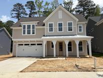 Charming two-story home featuring a two-car garage, covered porch, and light gray siding at 9152 Dupree Meadow Dr # 12, Angier, NC 27501