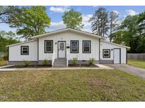 Charming home featuring a well-maintained lawn and a welcoming front porch with gray trim at 1001 Helms Pl, Raleigh, NC 27610