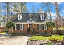 Charming brick home with dormer windows and meticulously landscaped front yard at 1424 Greenside Dr, Raleigh, NC 27609