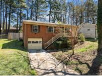 Charming brick home with a single-car garage and landscaped front yard at 1507 Ridgeway Ave, Durham, NC 27701
