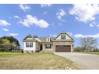 Charming two-story home with stone accents, a two-car garage, and a well-manicured lawn at 151 S Harper Faith Way, Benson, NC 27504