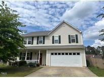 Charming two-story home with a well-manicured lawn and attached two car garage at 1643 Southcross St, Fuquay Varina, NC 27526