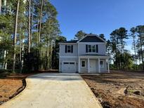 Charming two-story home featuring a one-car garage, a welcoming porch and a neatly paved driveway at 187 Regis Ln # 10, Coats, NC 27521