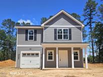 Charming two-story home with gray siding, black shutters, and a covered front porch at 205 Regis Ln # 11, Coats, NC 27521