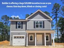 Charming two-story home featuring gray siding, white trim, and an attached single-car garage at 205 Regis Ln # 11, Coats, NC 27521