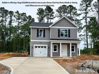 Charming two-story home with gray siding, white trim, attached garage, and inviting front porch at 205 Regis Ln # 11, Coats, NC 27521