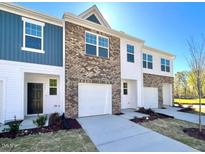 Charming townhome with attached garages, lovely brick and siding accents and a well manicured lawn at 2123 Trailside Dr, Durham, NC 27704