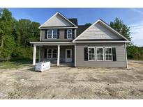 Charming two-story home featuring gray siding, black shutters and a welcoming front porch with stone accents at 226 Rolling Pasture Way, Sanford, NC 27332
