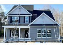 Charming two-story home with gray siding, black shutters, and multiple ladders leaned against the exterior walls at 226 Rolling Pasture Way, Sanford, NC 27332