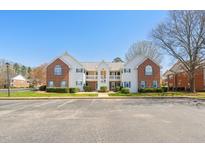 Exterior view of brick and white condo building with blue shutters and a well-maintained landscape at 2621 Wellington Ridge Loop, Cary, NC 27518
