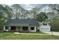 Charming home featuring a covered porch, attached garage, and mature trees, offering classic curb appeal at 2820 Mattlyn Ct, Raleigh, NC 27613