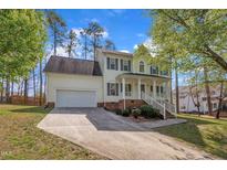 Charming two-story home featuring a welcoming front porch, attached garage, and beautifully landscaped yard at 3 Guilder Cv, Durham, NC 27713