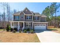 Charming two-story home features a stone accent, large front porch, and a well-maintained yard at 40 Poplar Bark Dr, Youngsville, NC 27596
