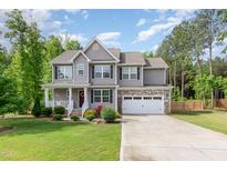 Charming two-story home featuring stone accents, manicured lawn and an attached two-car garage at 40 Poplar Bark Dr, Youngsville, NC 27596